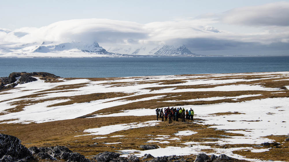 Several people at a landing off the Arctic Ocean