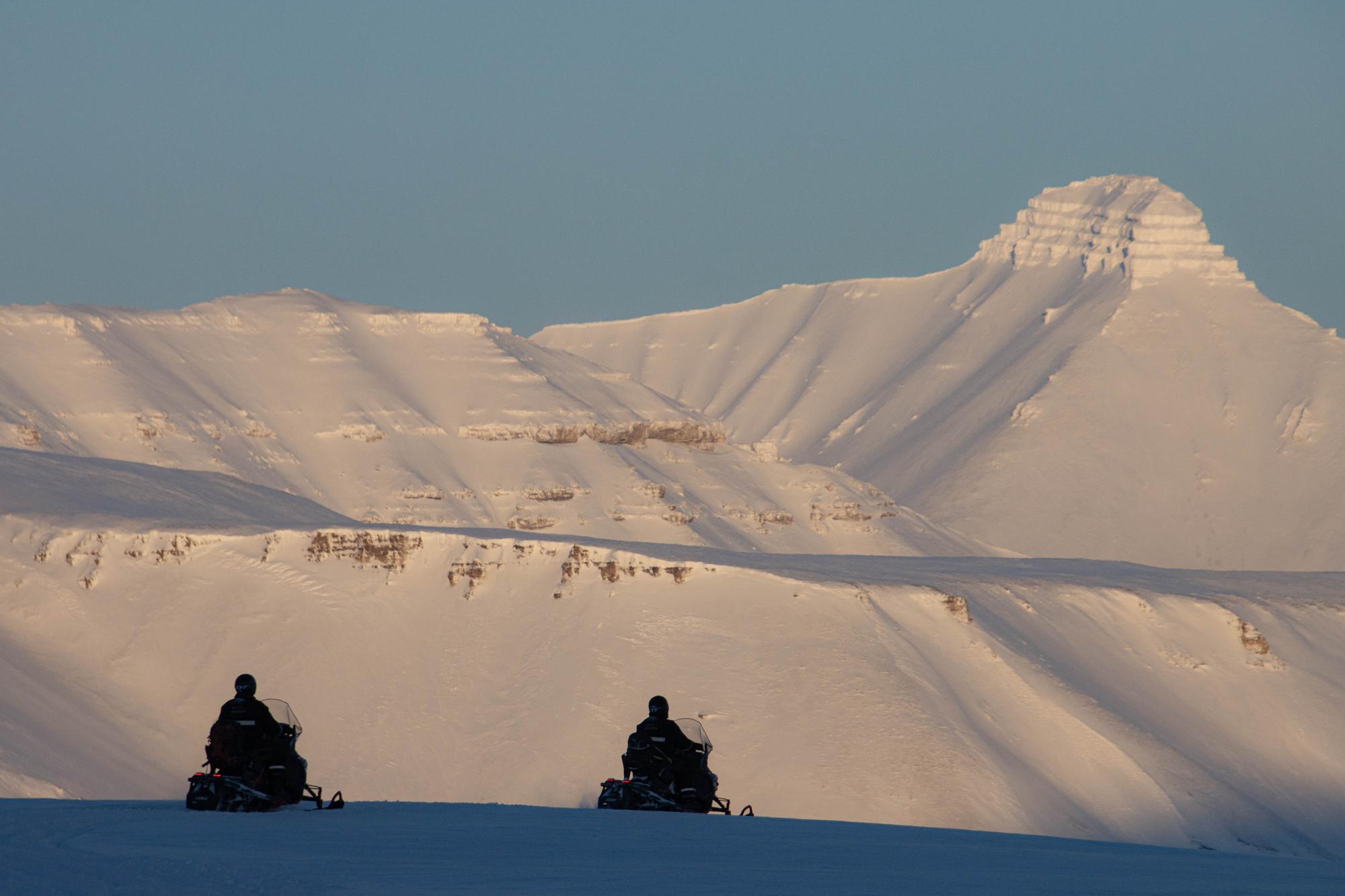 Snowmobile tour in the setting sun
